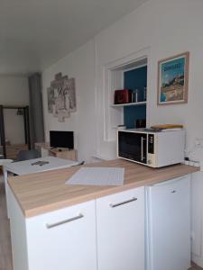 a kitchen with a microwave on top of a counter at Studio Dinard in Dinard +6 photos