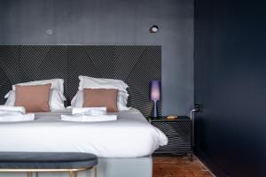 a bedroom with a large white bed with a black wall at Casa Mila Loire - L'expérience Hôtel & Spa - Angers Saumur in Saint-Mathurin