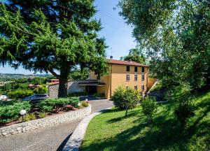 uma casa com uma árvore e uma entrada em Hotel Belvedere em Manerba del Garda