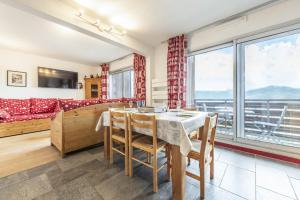 een woonkamer met een tafel, stoelen en een bank bij Smartstay - Appartement cosy courchevel 1850 in Courchevel