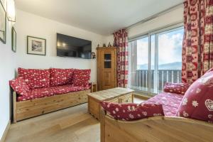 een woonkamer met een bank en een raam bij Smartstay - Appartement cosy courchevel 1850 in Courchevel