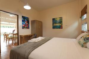 Un dormitorio con una cama grande y un comedor. en Coral Lagoon Pool Villa Rawai - Adult Only, en Rawai Beach