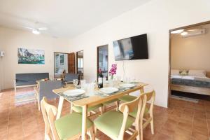 Un comedor y una sala de estar con mesa y sillas. en Coral Lagoon Pool Villa Rawai - Adult Only, en Rawai Beach