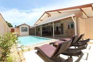 Un patio con sillas y una piscina. en Coral Lagoon Pool Villa Rawai - Adult Only, en Rawai Beach