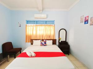 Un dormitorio con una cama con una manta roja. en YUTAKA INN Araya Malang, en Blimbing 22 fotos más