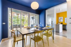 a dining room with blue walls and a table and chairs at Casa Conca in Alba