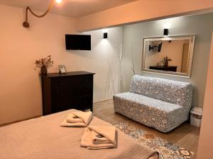 a bedroom with a bed and a chair and a mirror at Guest House Malusha in Gabrovo