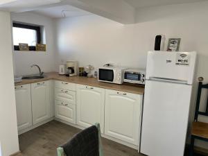 a kitchen with white cabinets and a white refrigerator at Guest House Malusha in Gabrovo