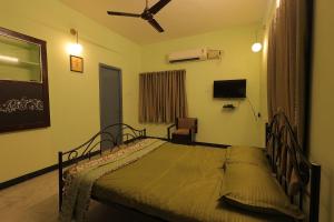 a bedroom with a bed and a ceiling fan at Day One's Kalyanam - Service Apartment in Madurai