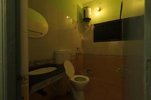 a small bathroom with a toilet and a sink at Day One's Kalyanam - Service Apartment in Madurai