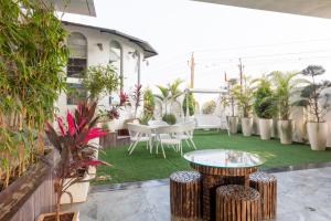 un patio avec une table, des chaises et des plantes dans l'établissement Heritage Home Stay, à Ujjain