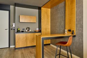 a kitchen with a counter and a stool in a room at Adella Boutique Hotel - Free Secured Parking in Sofia