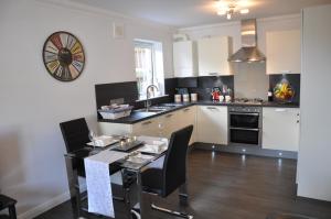 a kitchen with a table with chairs and a sink at Westgate Apartments Birchlee in Inverurie