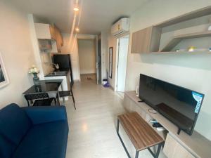 un soggiorno con una TV, un divano e un tavolo di 素坤逸50巷一房一厅免费Wi-Fi简单安静可做饭交通方便 a Amphoe Phra Khanong