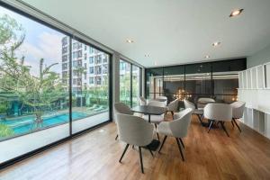 una sala da pranzo con tavolo e sedie e una grande finestra di 素坤逸50巷一房一厅免费Wi-Fi简单安静可做饭交通方便 a Amphoe Phra Khanong