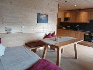 a living room with a table and a kitchen at Ferienwohnungen Tauernalm in Heiligenblut