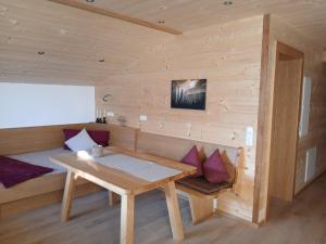 a wooden room with a wooden table and purple pillows at Ferienwohnungen Tauernalm in Heiligenblut