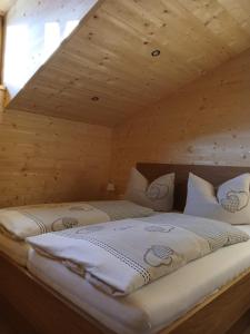 a large bed in a room with a wooden ceiling at Ferienwohnungen Tauernalm in Heiligenblut