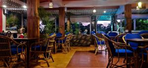 a restaurant with blue chairs and tables in a room at Thomson by the Beach in Candolim