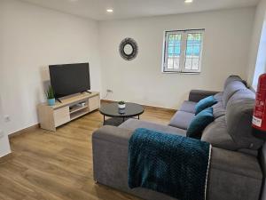a living room with a couch and a tv at Destro village in Lindoso