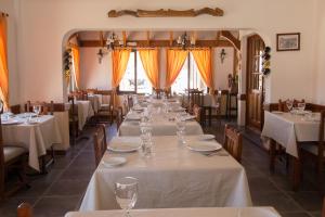 a row of tables in a restaurant with white table linen at Hualcupén Alfa in Copahue