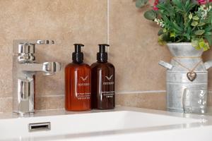 zwei Flaschen Seife auf einem Waschbecken in der Unterkunft heft view at rose cottage - opp heft restaurant in Grange Over Sands