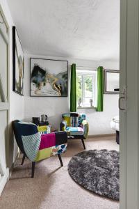 ein Wohnzimmer mit zwei Stühlen und einer Couch in der Unterkunft heft view at rose cottage - opp heft restaurant in Grange Over Sands