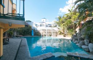 a swimming pool with blue water and palm trees at RedDoorz @ Yahweh Spring Retreat & Resort Laguna in Calamba
