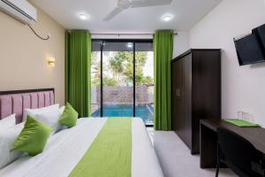 a bedroom with a bed and a desk with a television at Green Vibe Apartments in Nugegoda +73 photos