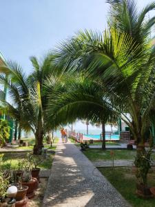 ein Weg mit Palmen und einem Strand im Hintergrund in der Unterkunft Hiep Hoa Resort in Mui Ne