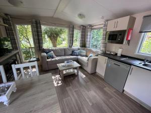 a living room with a couch and a kitchen at Chalet Steffis Casa del Sol Renesse in Renesse
