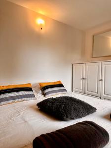 a bedroom with a bed with a black pillow on it at Les Jardins d'Ilona - Les Oliviers - Ecocon in Arques +29 photos