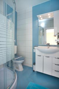 ein blaues Bad mit einem Waschbecken und einem WC in der Unterkunft Apartments Kristal in Kaštela + 55 Fotos