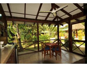 a kitchen with a table and chairs and a view of the garden at Las Brisas del Sur in Ojochal