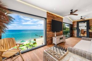 a living room with a large window with a view of the ocean at Aidan Beachfront Suites 5 Bed Lamai - KBR28 in Amphoe Koh Samui