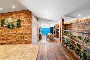 a living room with a brick wall and the ocean at Aidan Beachfront Suites 5 Bed Lamai - KBR28 in Amphoe Koh Samui