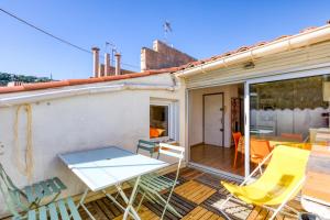 a patio with chairs and a table on a deck at Siesta Sete in Sète