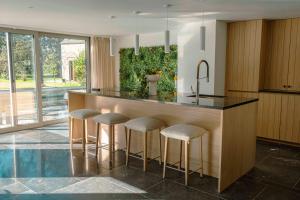 a kitchen with a counter with bar stools at Le verger de Paulin in Yvoir