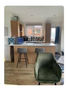 a kitchen with a green chair and a kitchen counter at Seaside 2 bed Chalet Escape in Mablethorpe in Mablethorpe