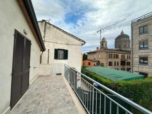 a balcony with a green awning and a building at Colle Rooms HELIANTHUS in Santa Maria degli Angeli