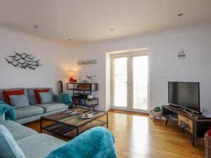 a living room with a couch and a tv at Tides Reach in Rhosneigr