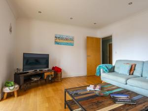 a living room with a couch and a television at Tides Reach in Rhosneigr