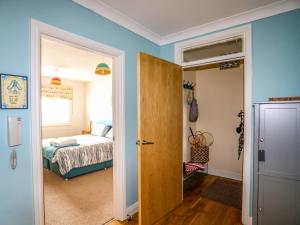 a bedroom with a bed and an open door at Tides Reach in Rhosneigr