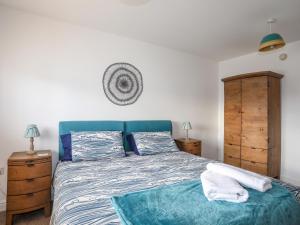a bedroom with a bed with a blue head board at Tides Reach in Rhosneigr