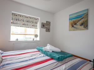 a bedroom with a bed with towels on it at Tides Reach in Rhosneigr