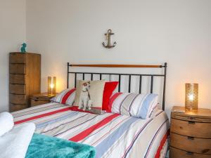 a bedroom with a bed with red and white pillows at Tides Reach in Rhosneigr
