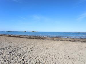 a sandy beach with the ocean in the background at Tides Reach in Rhosneigr