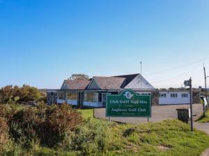 a sign in front of a house with a building at Tides Reach in Rhosneigr