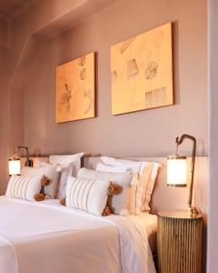 a bedroom with two beds with white sheets and two lamps at Le Jardin des Douars in Ghazoua