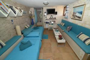 a living room with blue couches and a table at Villa Erato in Kineta